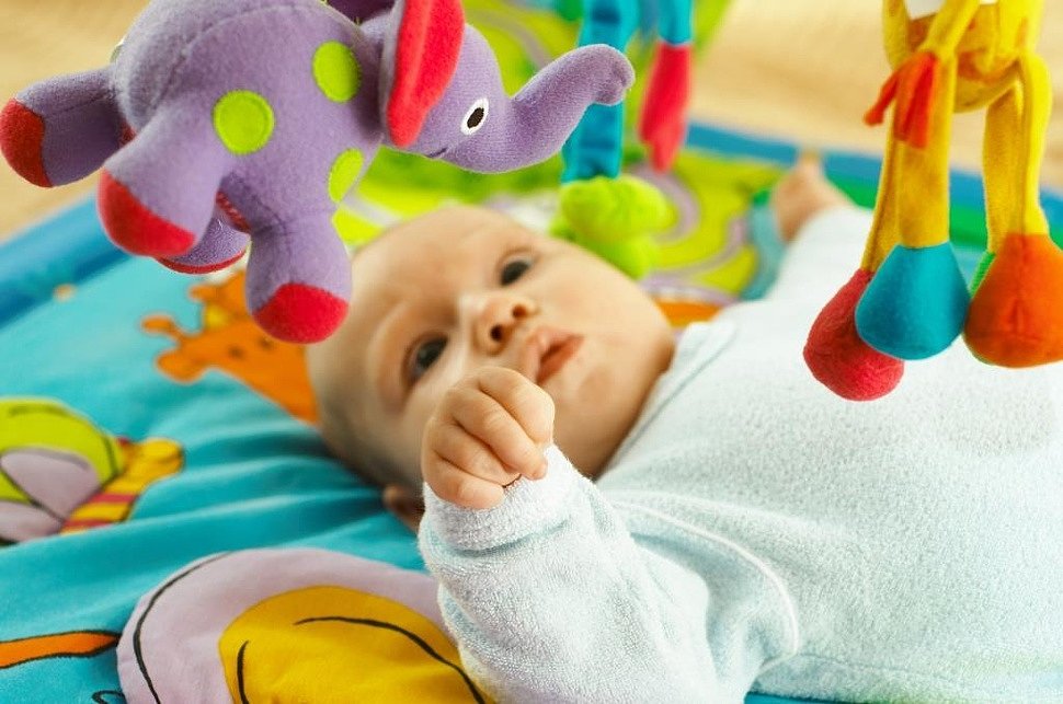 Когда купить первые игрушки для новорожденного и как их выбрать?